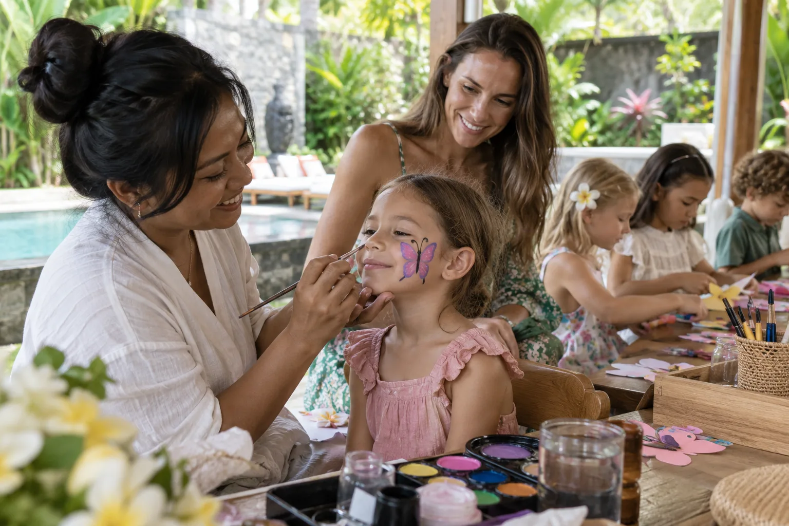 Face painter decorating a child’s cheek beside a shaded craft table