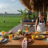 Private chef setting up a poolside dinner at a modern Berawa villa with rice field horizon
