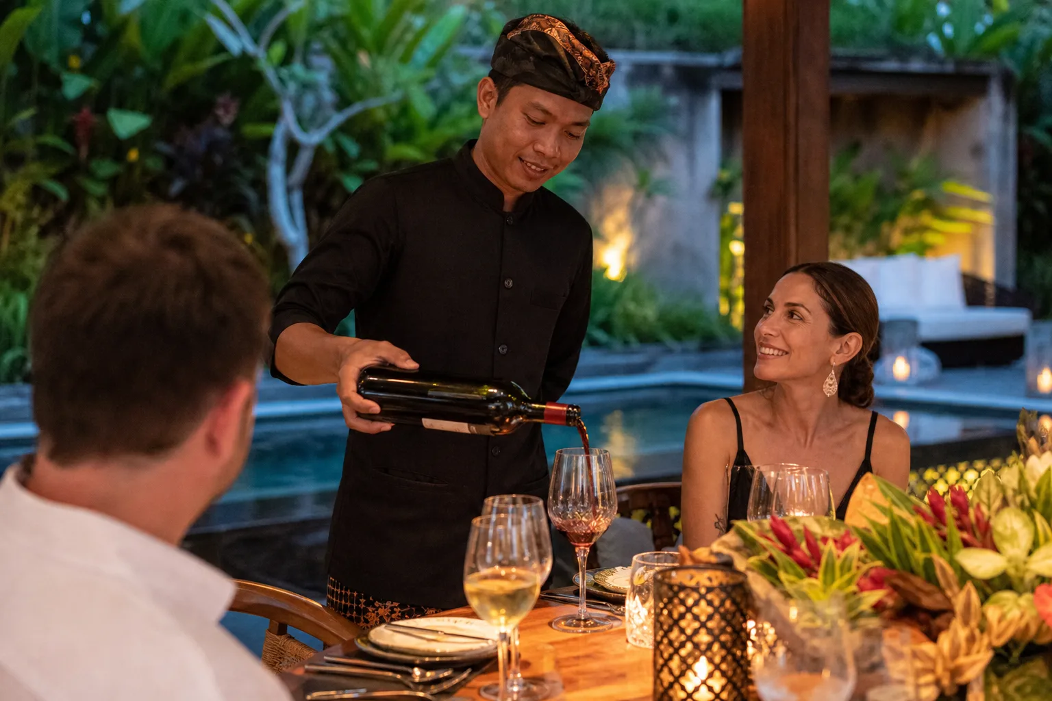 Villa waiter in Bali pouring red wine at an intimate private dinner