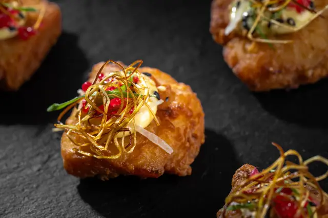 Golden fritter canapés with crispy leek and pomegranate