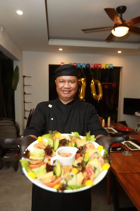 myCHEF chef presenting a large salad platter at a villa birthday dinner