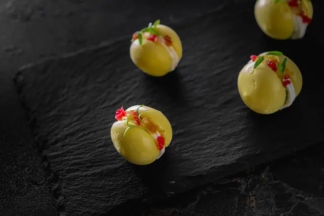 Green olive canapés dressed with cream and red pepper
