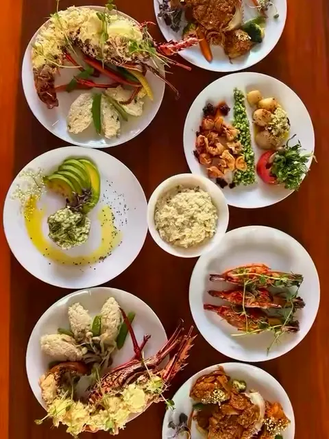 Overhead view of a myCHEF villa seafood lunch with lobster and prawn plates