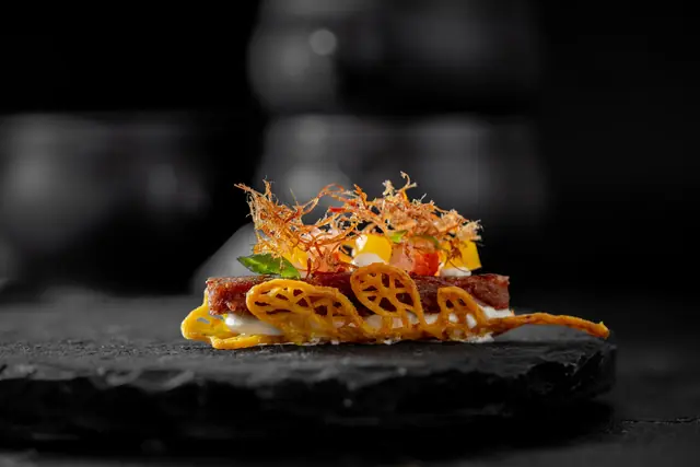 Canapé on a lattice crisp with diced mango and crispy shallots, by myCHEF